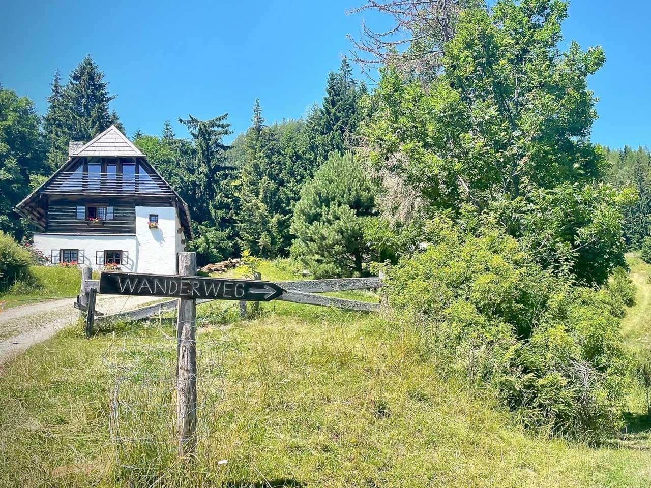 Amlhütte des Almretreats, davor ein Wanderwegschild